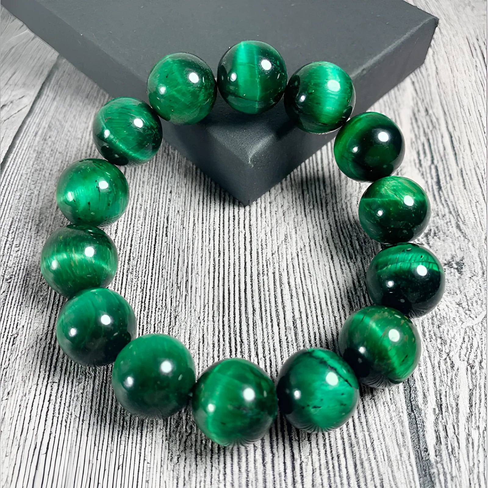 Green tiger eye gemstone bracelet with geometrically polished beads on a white background.