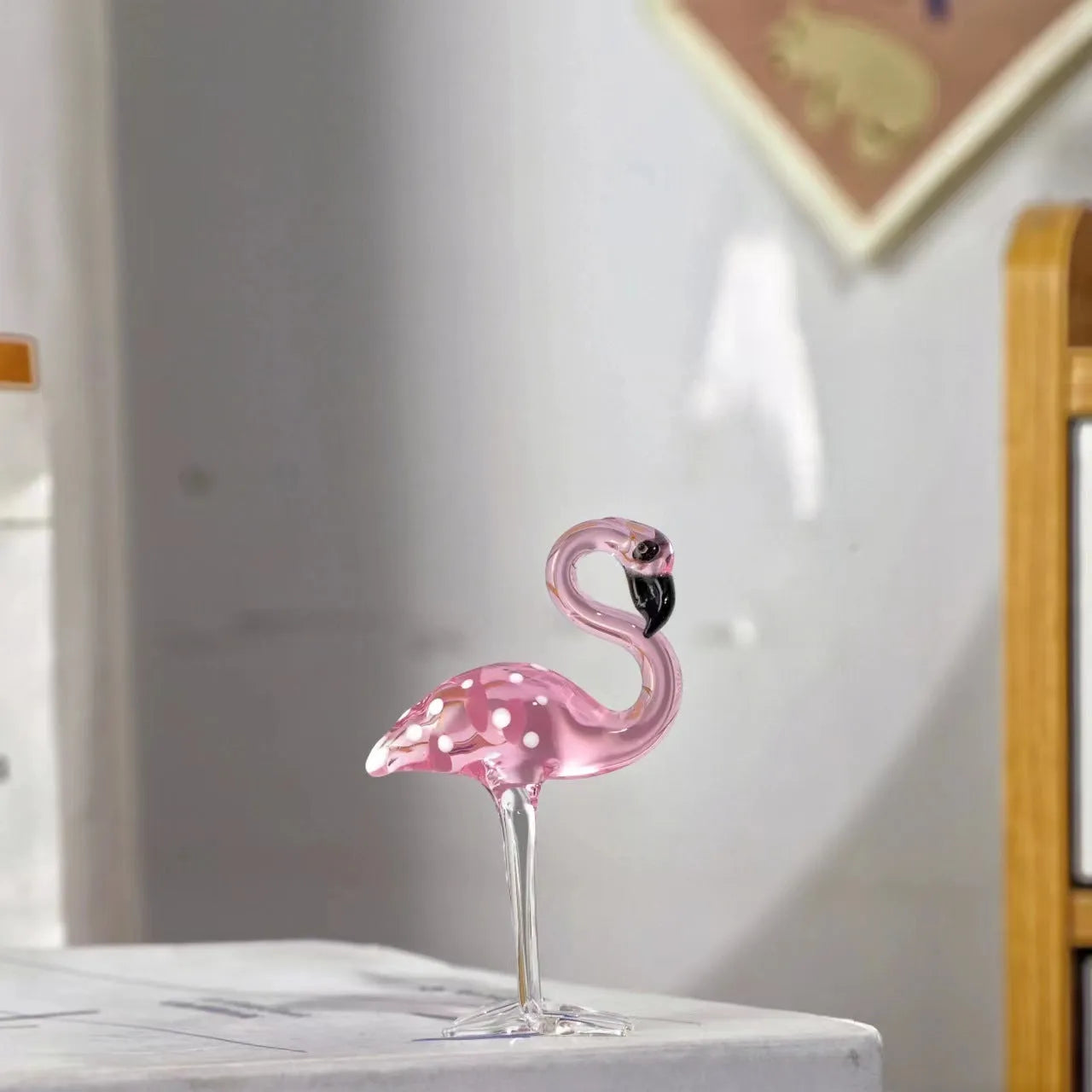 Pink and white crystal decorative flamingo table prop on a modern shelf