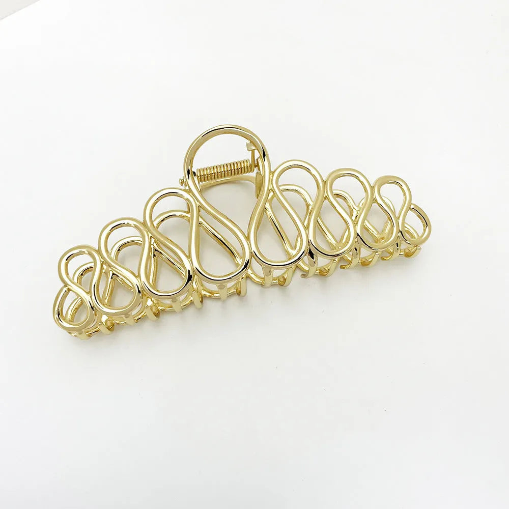 Large minimalist updo hair clip with tassel detail in gold or silver electroplated finish.