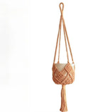 Hand-woven brown polyester cotton net pocket extension cord on a grey flower pot.