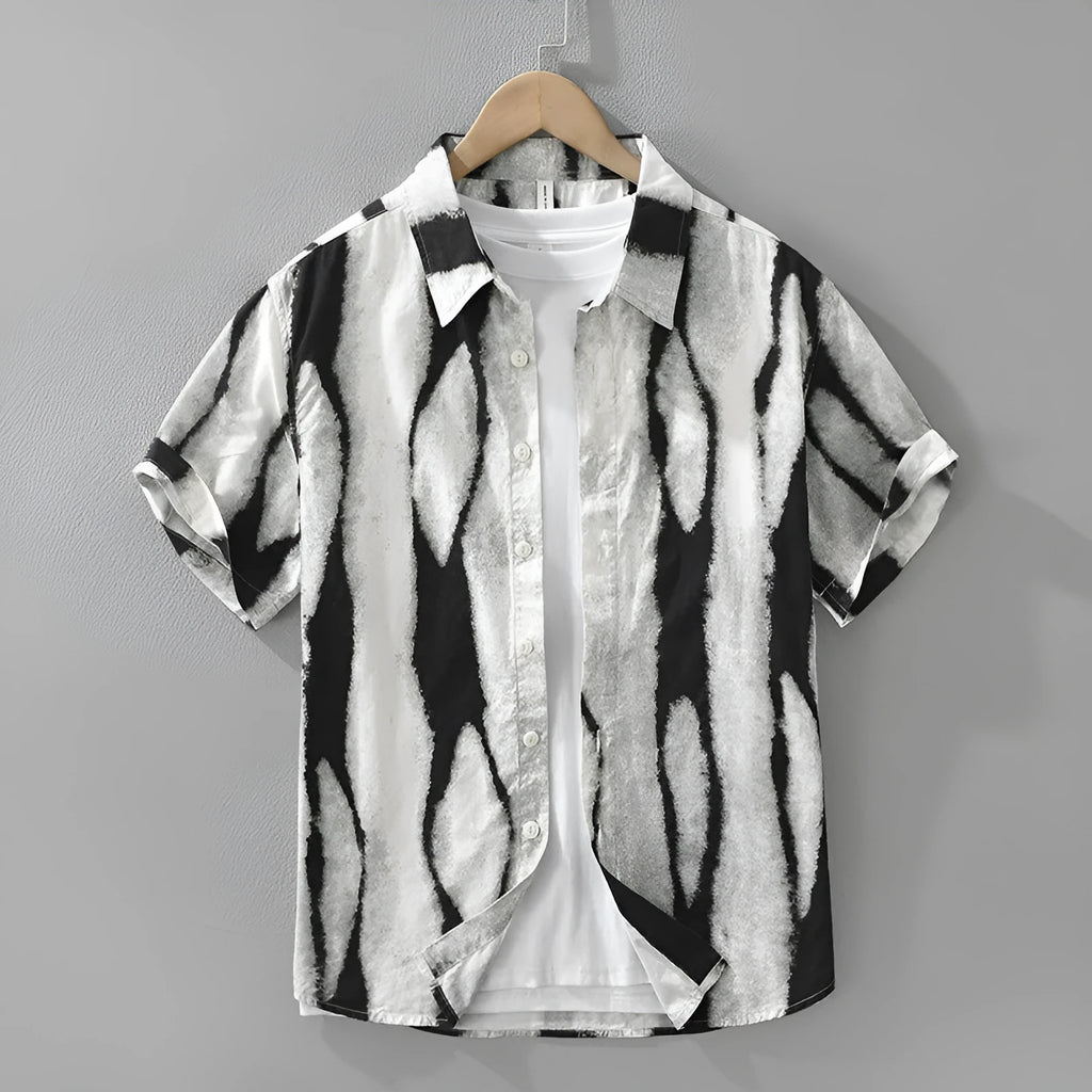 Man wearing a black and white retro striped loose-fit short sleeve cotton shirt.
