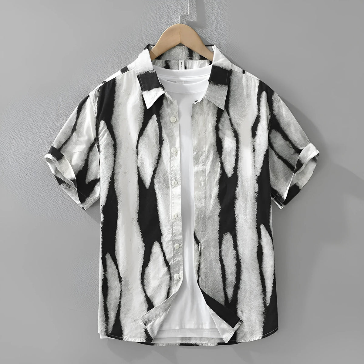 Man wearing a black and white retro striped loose-fit short sleeve cotton shirt.