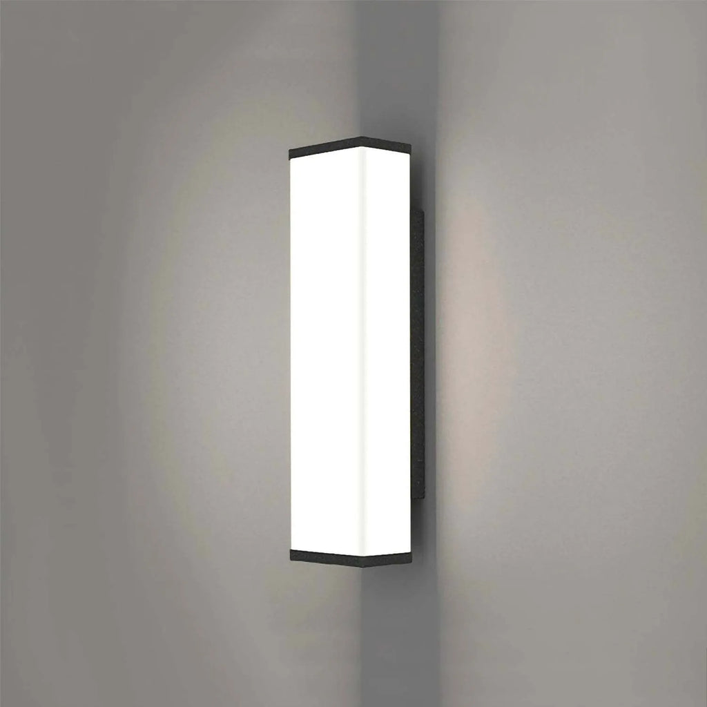 Long, slim stainless steel and plastic outdoor wall light mounted on a brick wall.