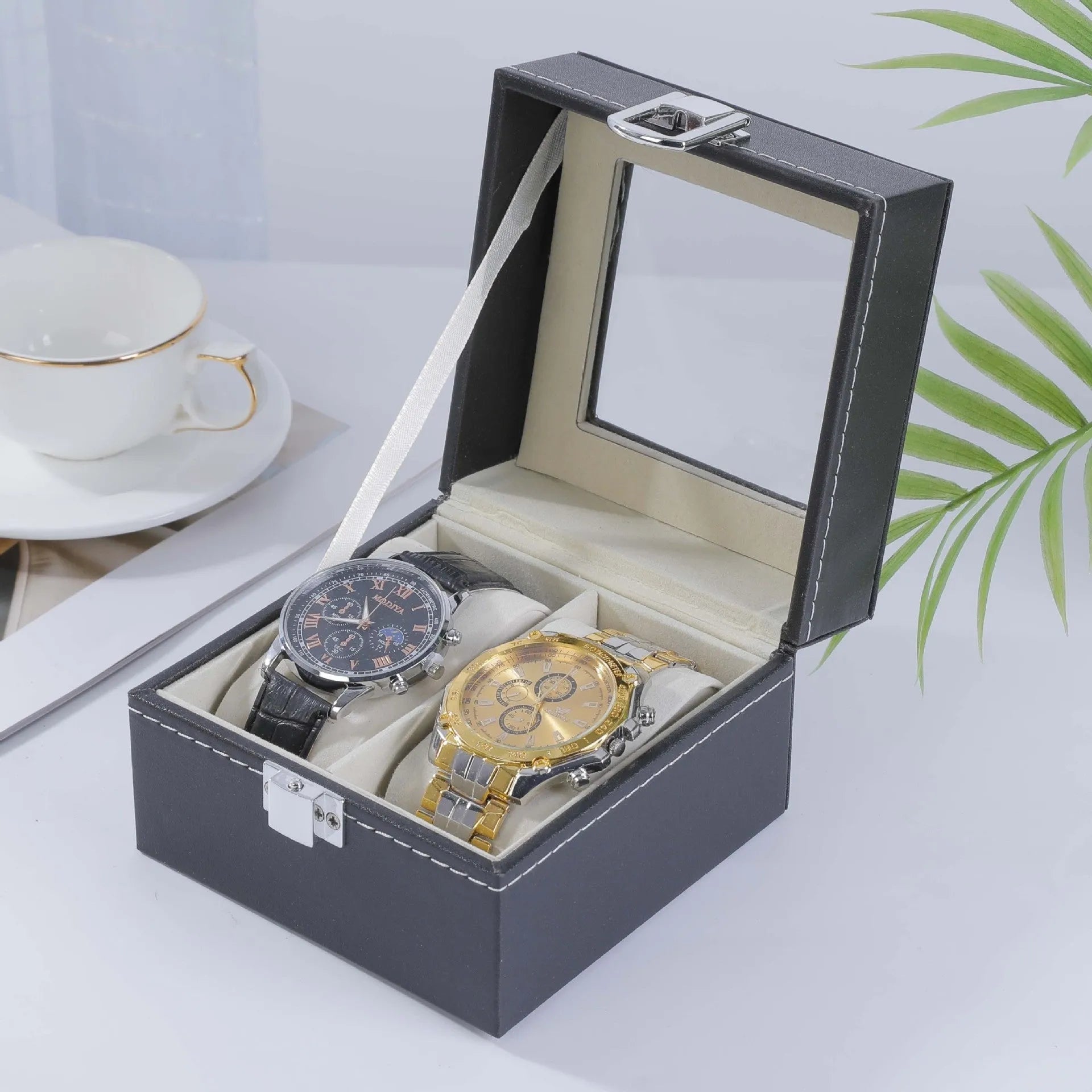 Grey leather watch storage box with transparent lid showing internal watch slots.