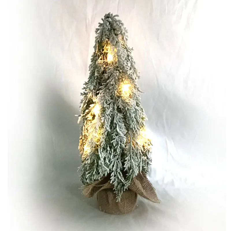 Small white 24-inch plastic Christmas tree with LED lights and simulated snow spray on desktop