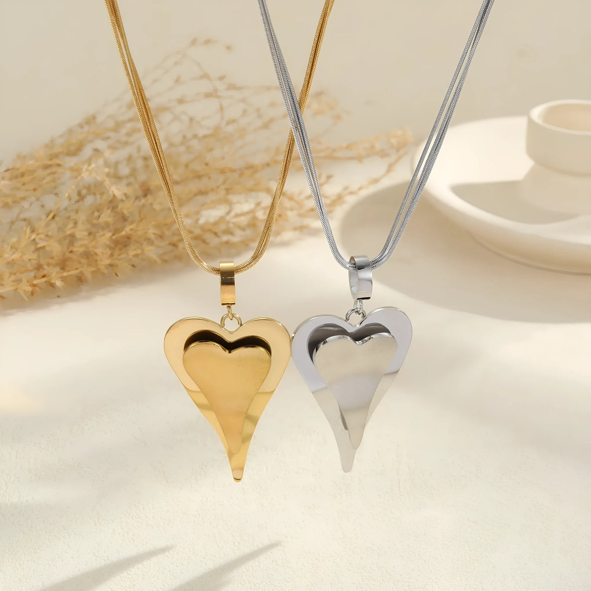 Women's stainless steel necklace with double heart geometric pendant featuring snake bones design in gold plating