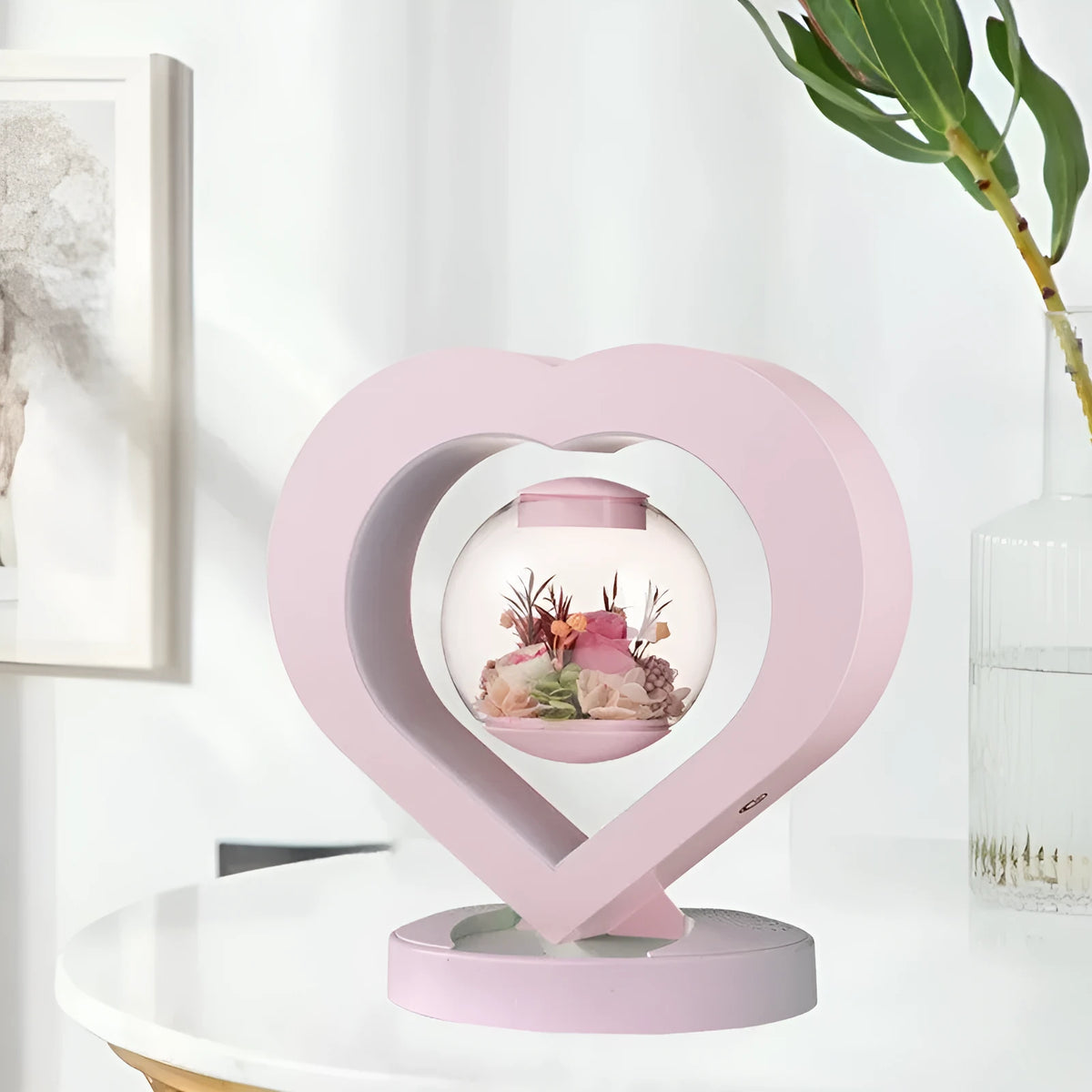 Pink preserved rose ornament with LED lights on a base with audio Bluetooth connectivity.