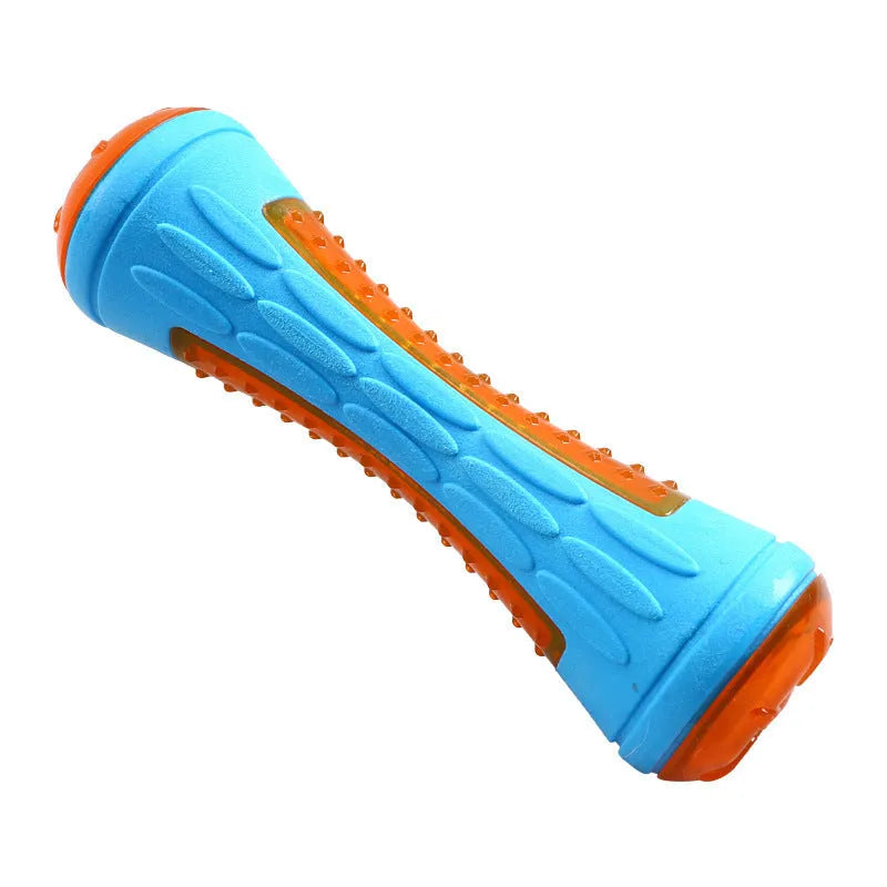 Set of three floating dog toys: a blue squeaky ball, an orange barbell, and red tyres on a beach.