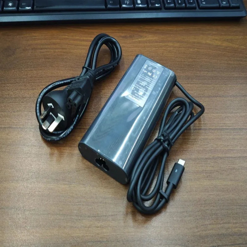 Black 65W USB-C laptop power adapter with six international plug cords for UK US EU AU SA and CN sockets