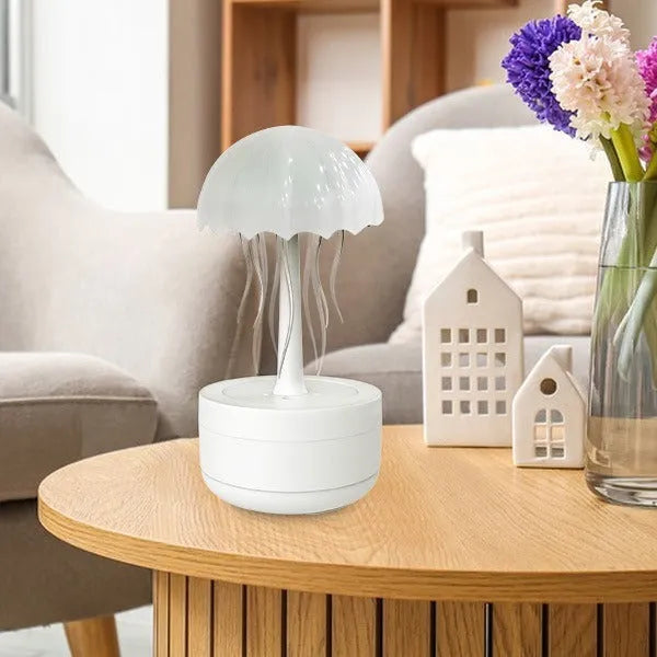White jellyfish-shaped aroma diffuser and humidifier with glowing coloured LED light on a desk.