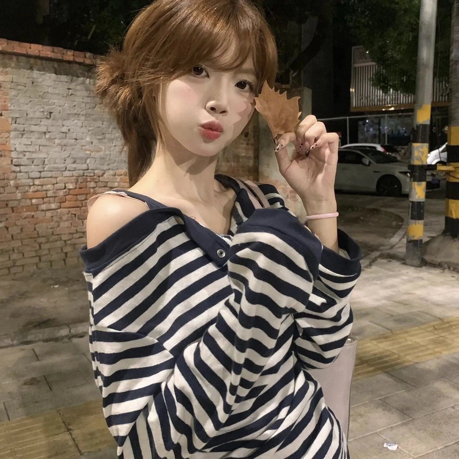 Dark blue oversized women's long-sleeved t-shirt with stripes and embroidery on a hanger.