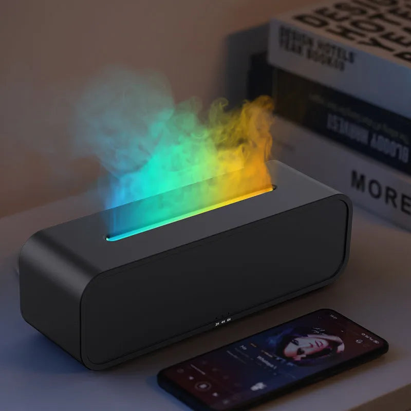 Black aroma diffuser with colour-changing flame light effect and remote control on a table.