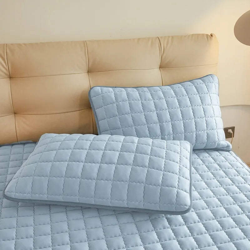 Class A waterproof washed cotton fitted sheet in light grey colour on a bed.
