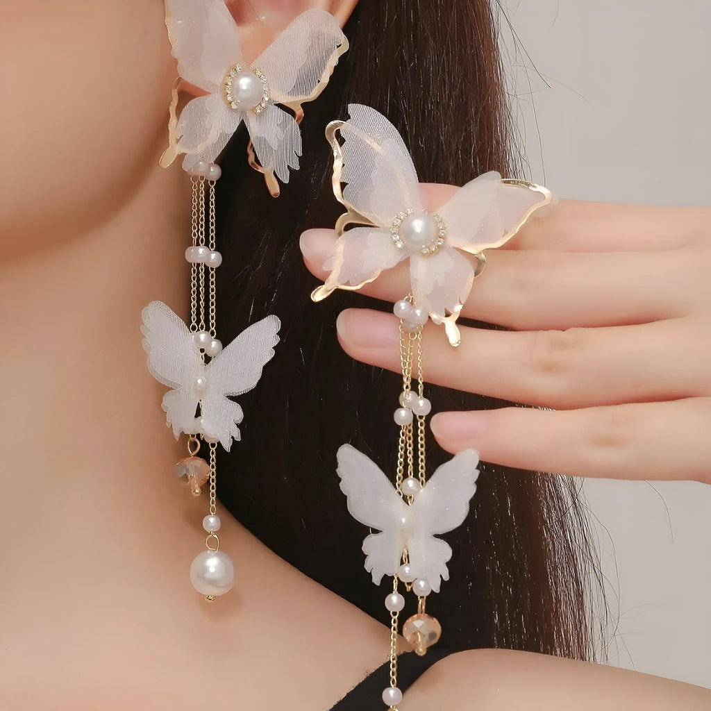 White butterfly earrings with rhinestone and pearl accents on copper alloy with lace tassels