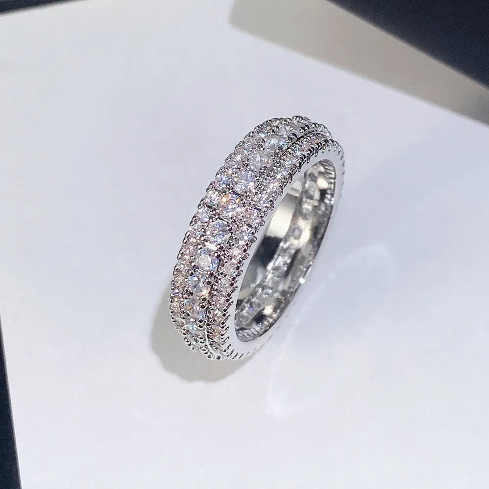 Geometric copper ring with a triangular zircon stone inlay, shown in white gold, yellow gold, and white and black plated finishes.