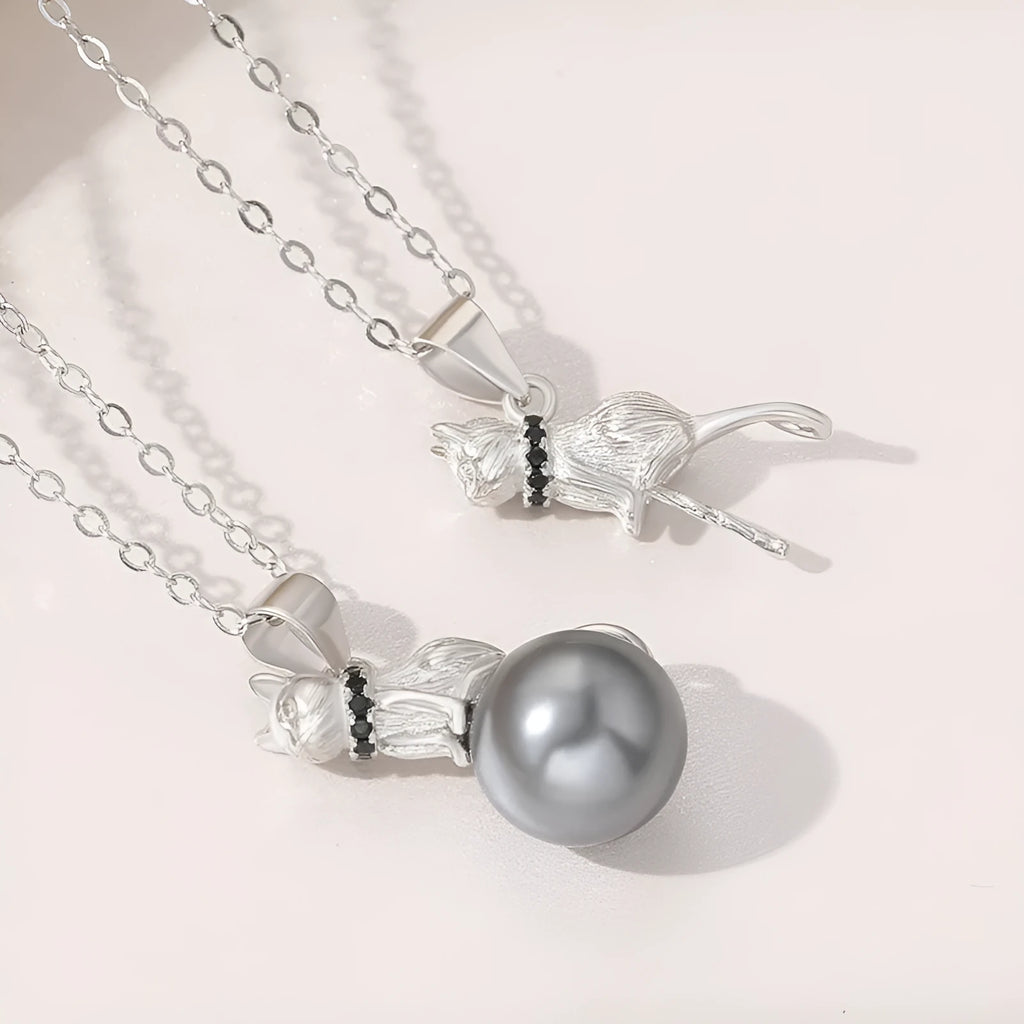 Close-up of a sterling silver cat pendant necklace on a clavicle chain.