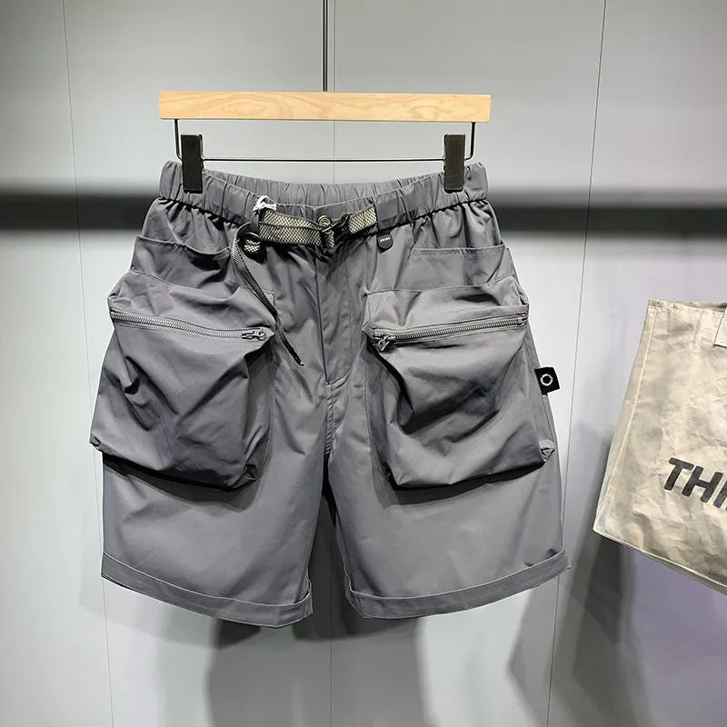 Men's loose fit grey workwear shorts with pockets, shown above the knee.