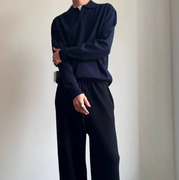 Men's navy blue loose fit wool polo sweater with a lapel collar on a hanger.