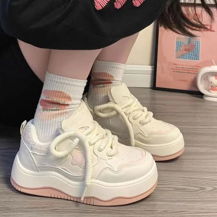 Women's green patent leather platform sneaker with round toe and white rubber sole on a pink background.