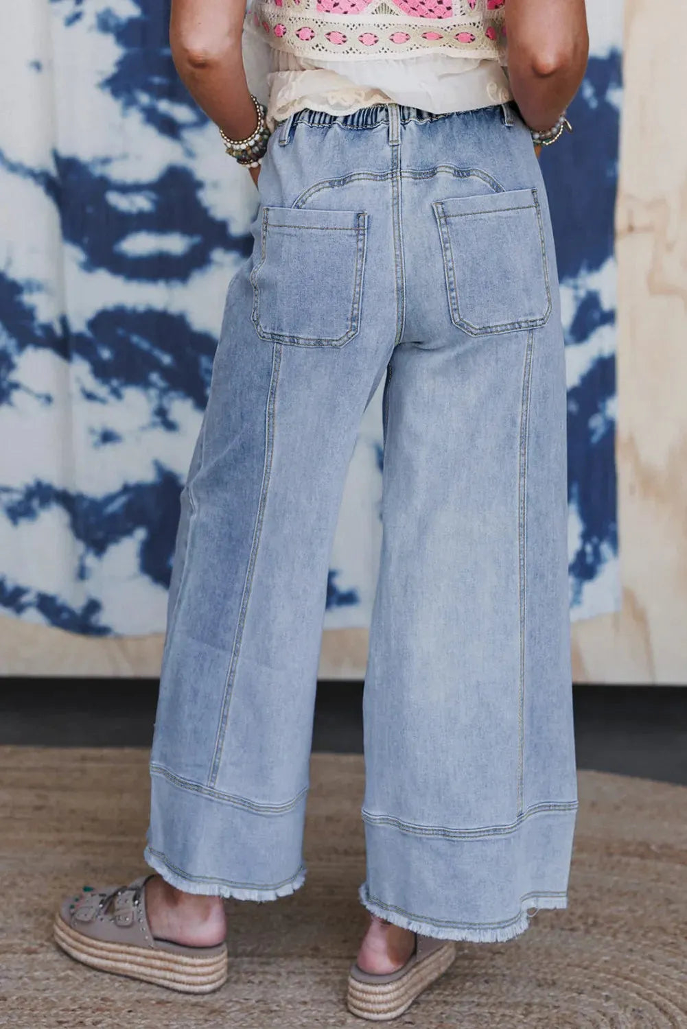 Beau Blue wide-leg women's jeans with a drawstring waistband and raw hem detail.