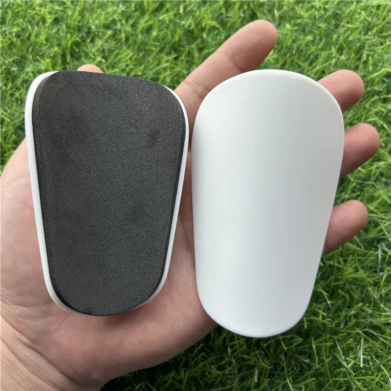 Extra small mini football shin guards in black and white colours showing 8x5cm plastic construction