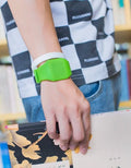 Square white electronic watch with digital display on wrist, showing touch screen and stainless steel buckle