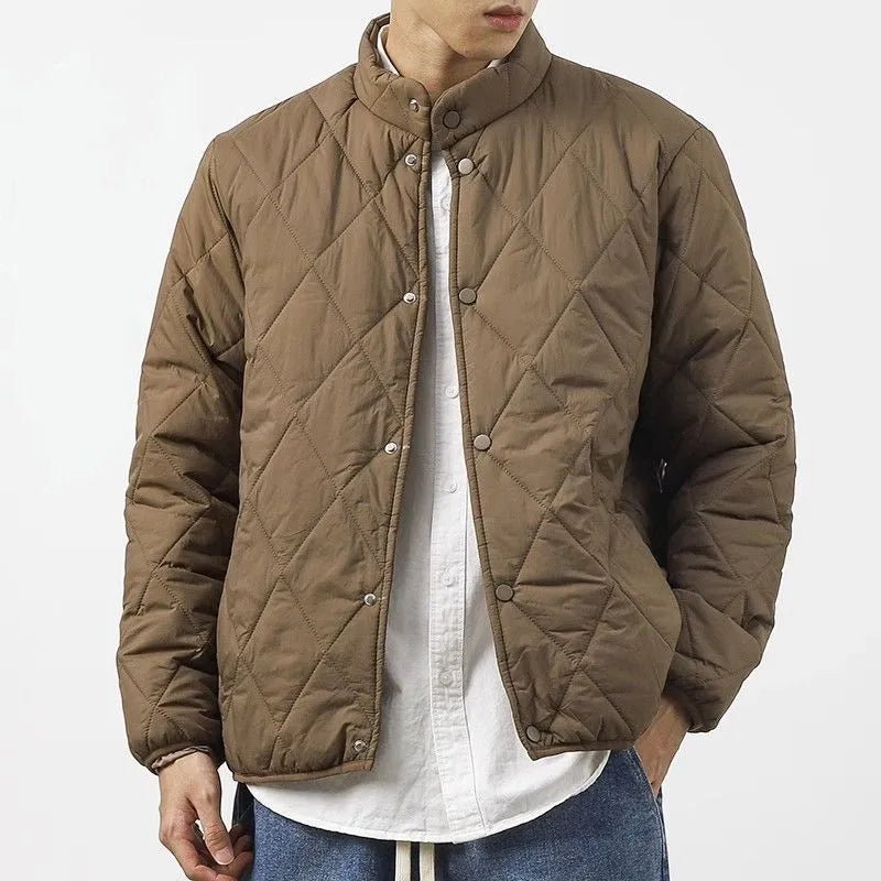 Man wearing a black diamond quilted longline winter jacket with a loose fit.