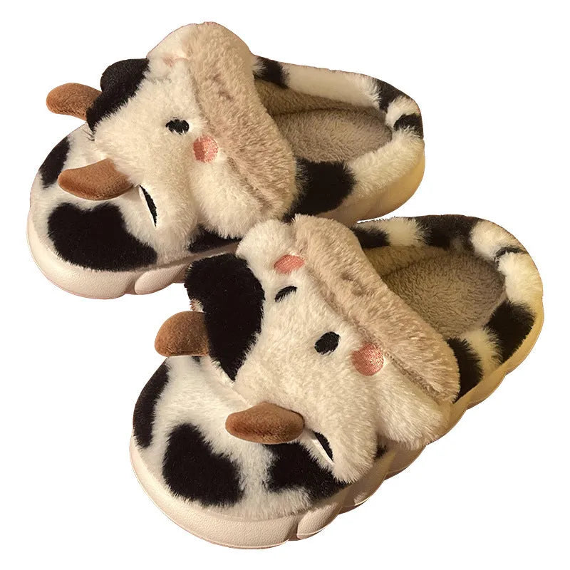 White plush cow slippers for women with black spots, a smiling face, and a textured non-slip sole.