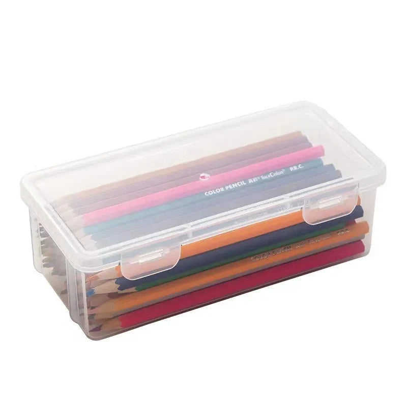 Transparent plastic stationery storage box containing pencils, colour leads, and art supplies
