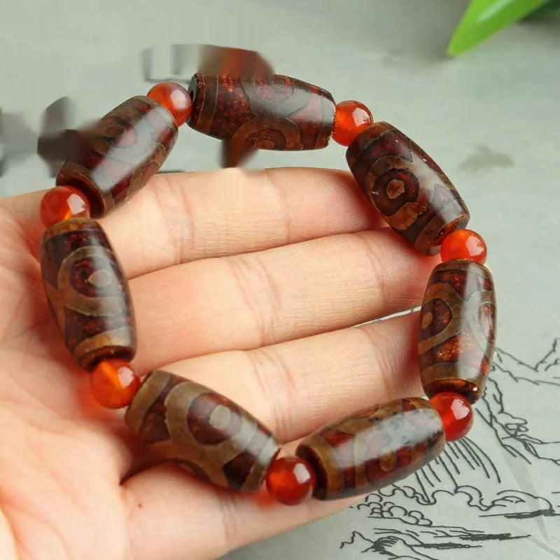 Distressed agate bracelet with traditional Tibetan dzi beads including three-eye and Nine Eyes designs.