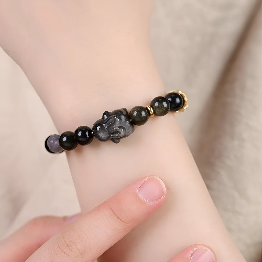 Handmade grey agate and silver lying rabbit charm bracelet on wrist, showing 10mm bead size option.