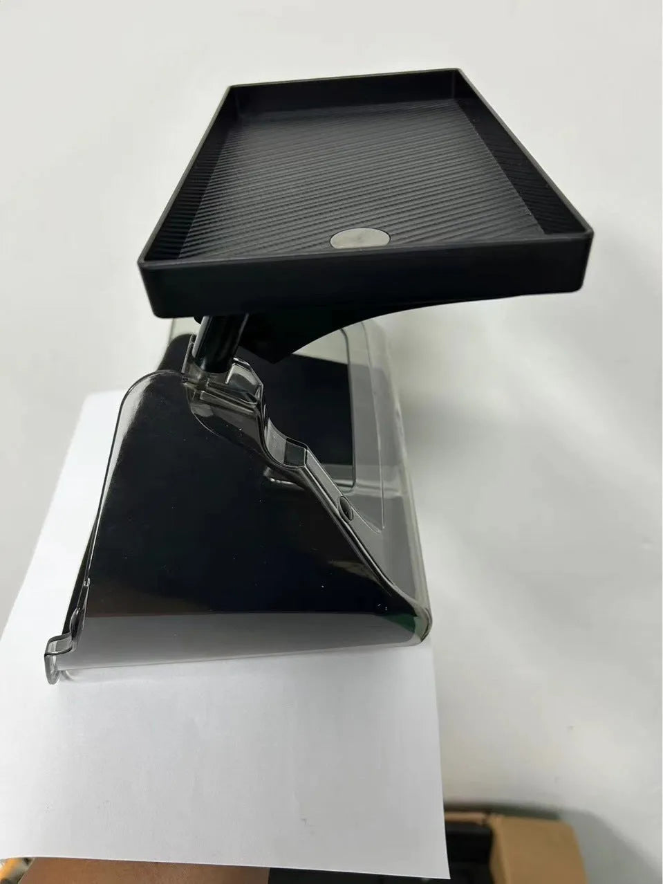 Black ABS plastic storage box installed under the touchscreen in a Tesla Model Y centre console.
