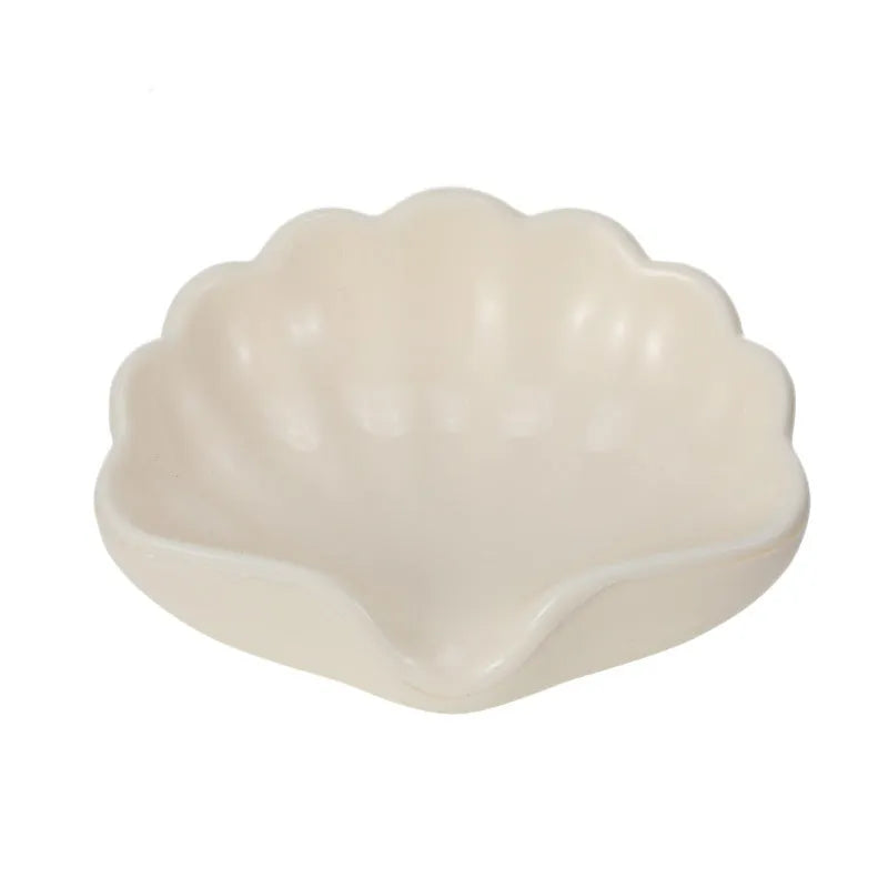 Shell-shaped white plastic soap dish with raised base for bathroom use