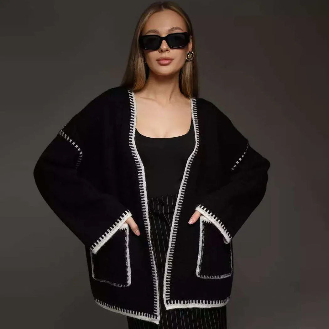 Loose mid-length knitted cardigan sweater coat with a lace-up front, shown in a neutral colour.