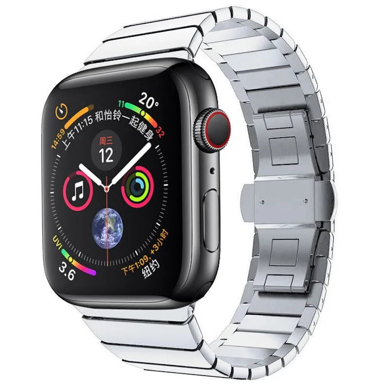 Silver stainless steel Apple Watch strap with butterfly buckle on a wrist.