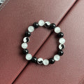 Close-up of a natural opal Tai Chi beaded bracelet with 10mm polished stones on a wrist.