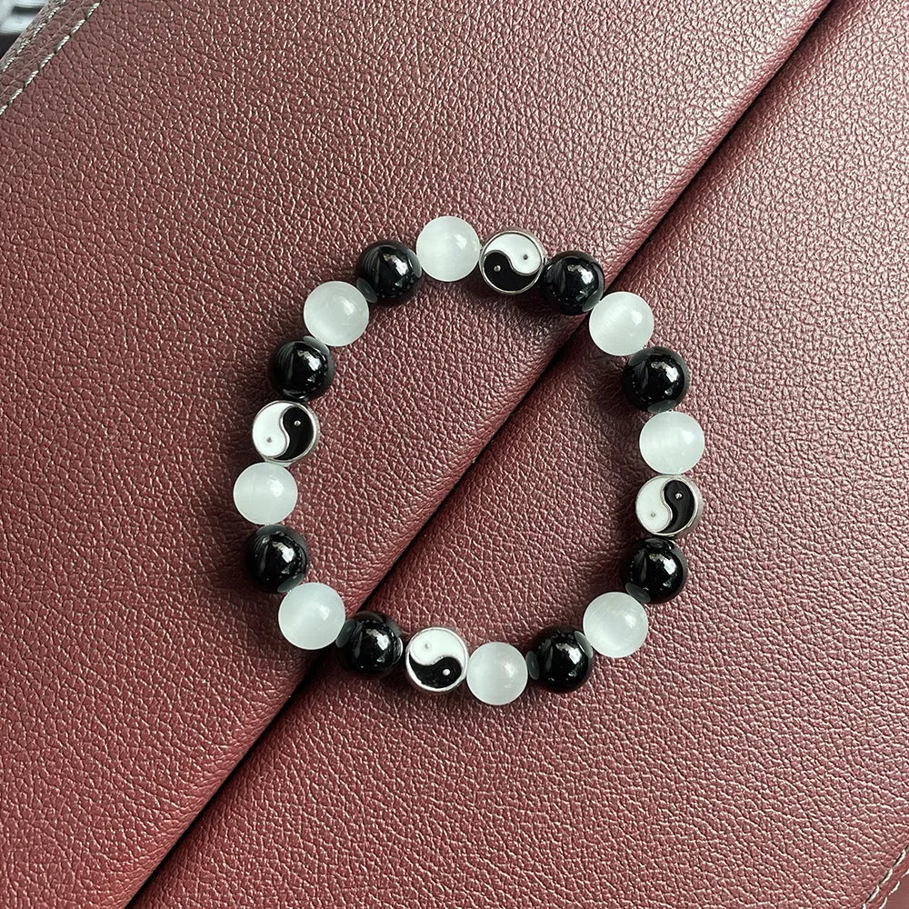 Close-up of a natural opal Tai Chi beaded bracelet with 10mm polished stones on a wrist.