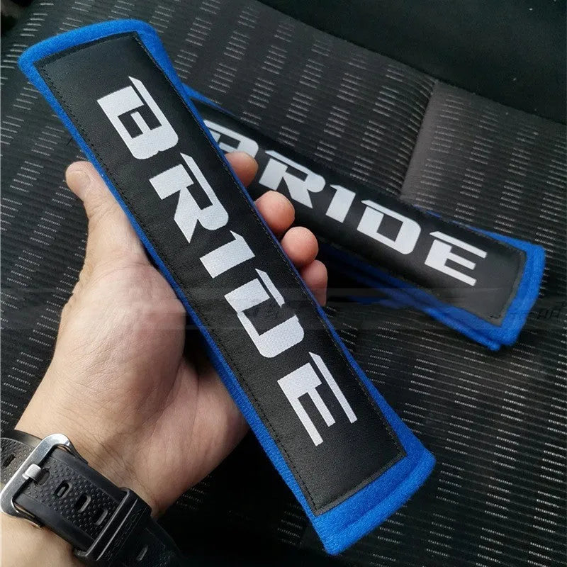 Pair of black car seat belt shoulder pad sleeves with embroidery detail, showing dimensions.