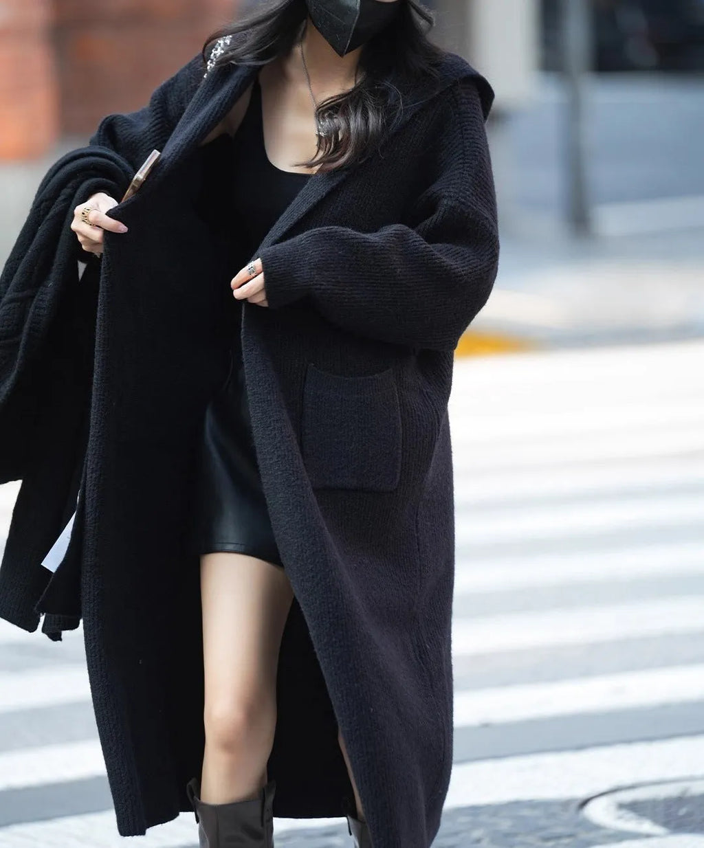 Long grey knitted hooded trench coat shown on a model, cardigan style with long sleeves.