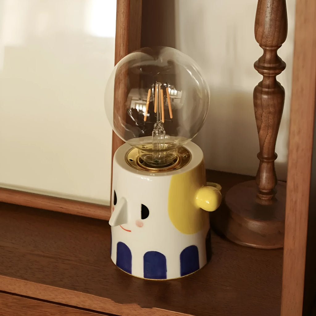 Handmade ceramic ball headlight bedside lamp on a table.