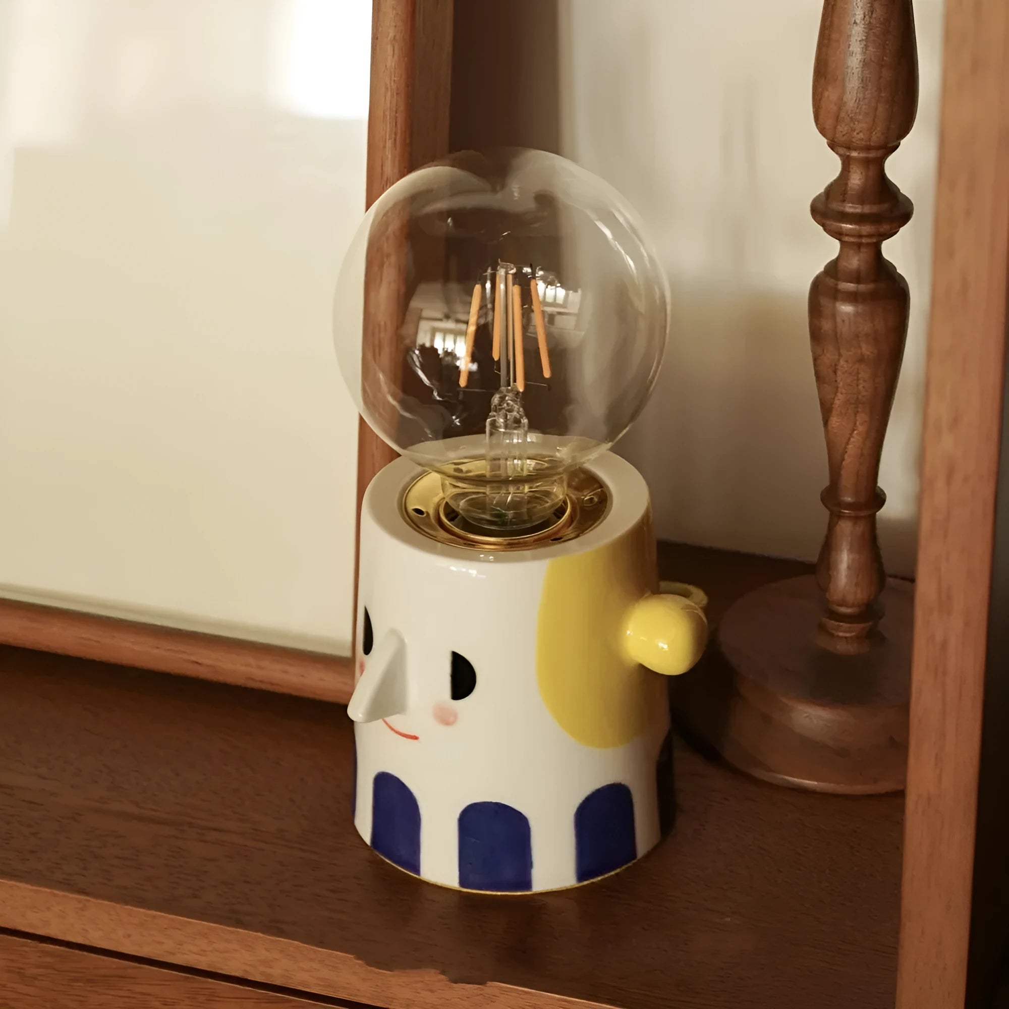 Handmade ceramic ball headlight bedside lamp on a table.