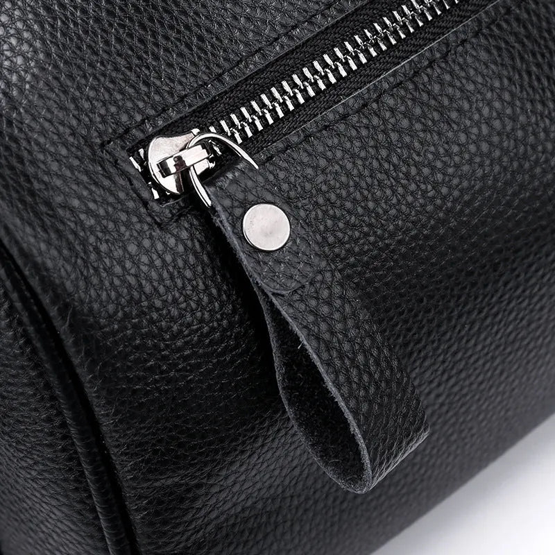 Black genuine leather one-shoulder crossbody bag showing front view and spacious interior.