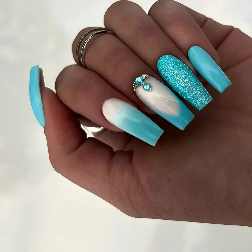 Solid blue long ballet shaped false nail art patches with a bottle of adhesive glue on a white background.