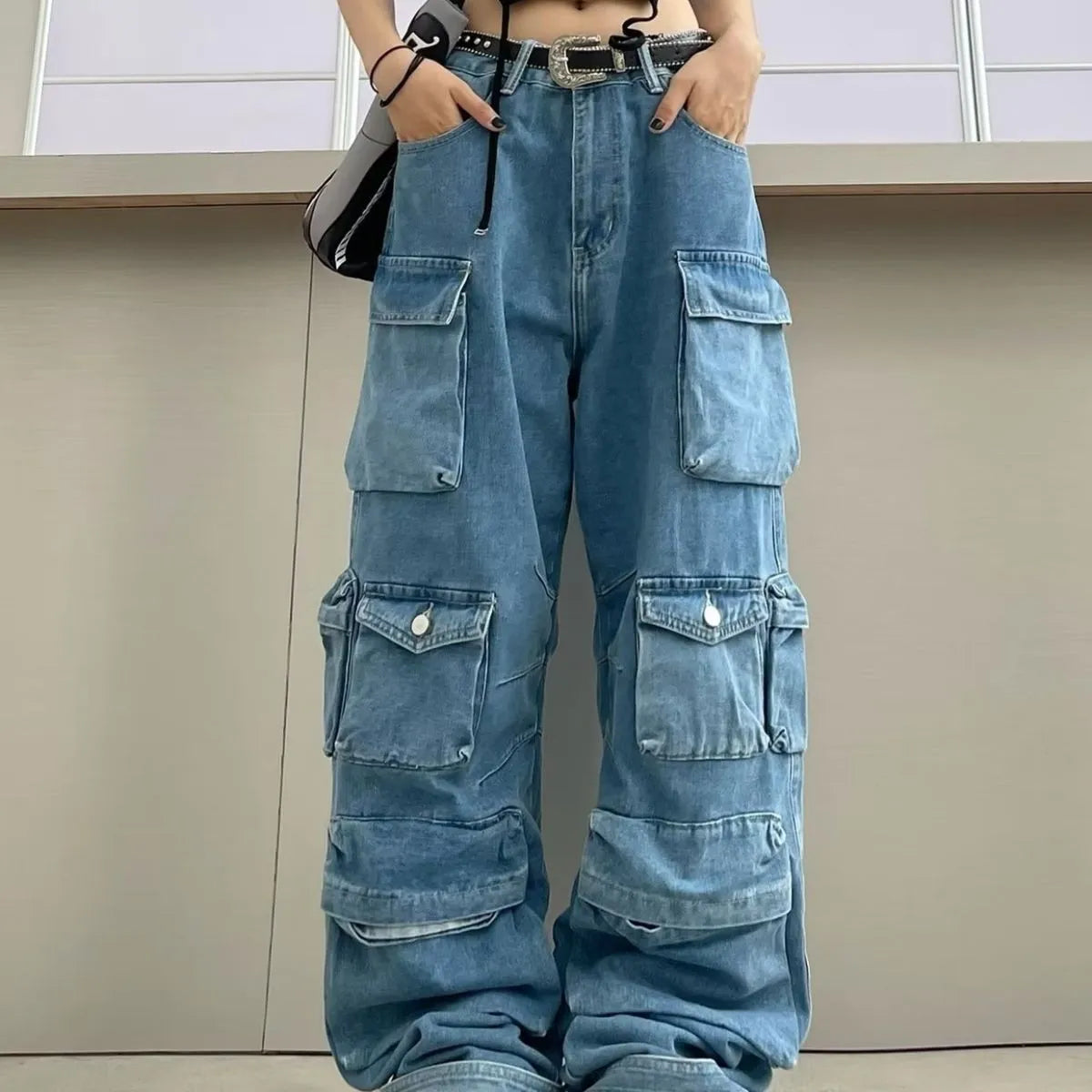 Women's blue tie-dyed high-waist wide-leg jeans with multiple pockets on a neutral background