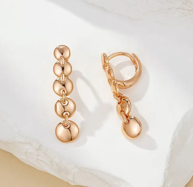 Long gold retro circle earrings with woven chain design, shown from the side.