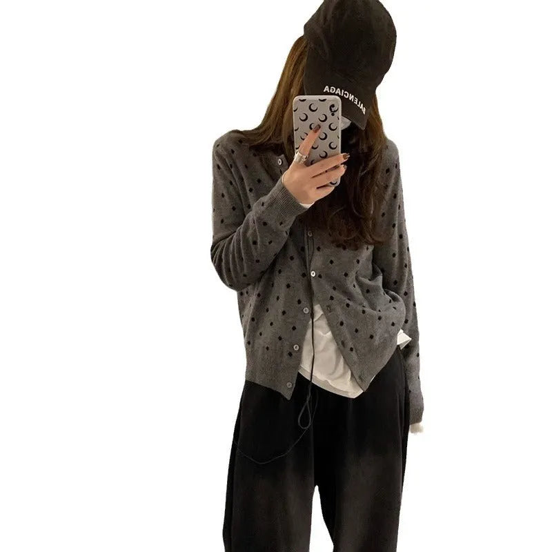 Grey women's knitted cardigan with a crocheted flower decoration on the front.