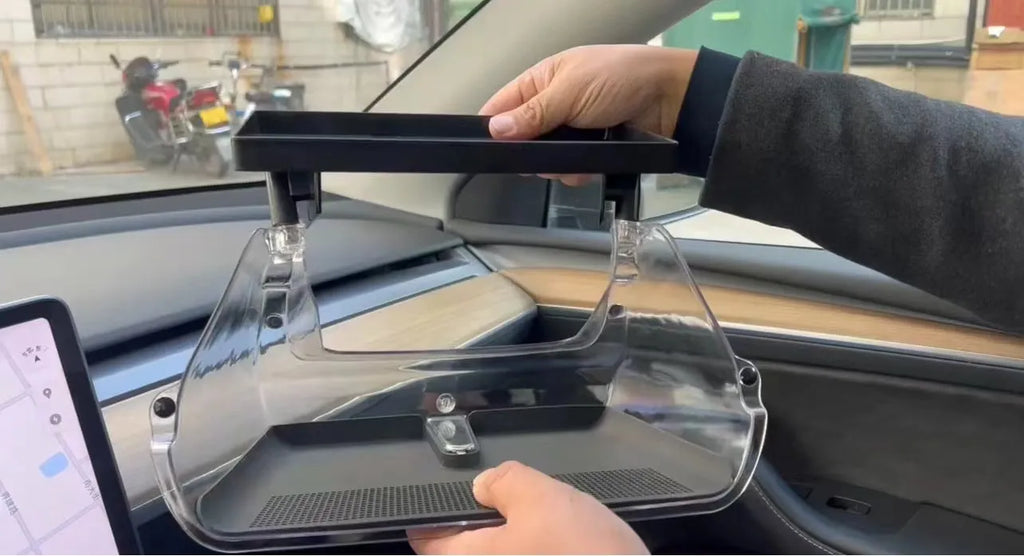 Black ABS plastic storage box installed under the touchscreen in a Tesla Model Y centre console.