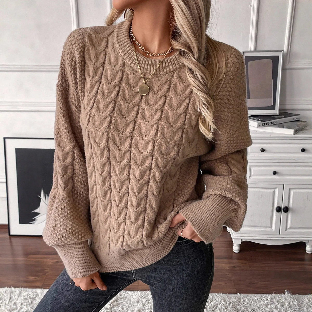 Women's beige loose-fitting sweater with twisted detailing on a hanger.