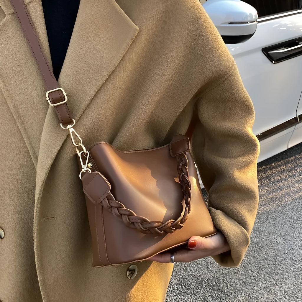 Khaki PU woven one-shoulder crossbody bucket bag with retro design on a mannequin