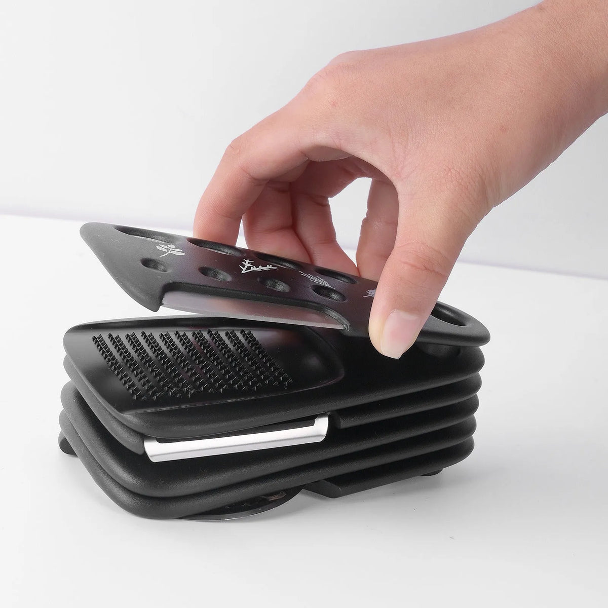 Six stackable kitchen gadgets including peelers, a brush, and tongs in a colour box.